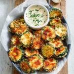 Oven-crisped zucchini slices are easily made and beautifully displayed as a delicious and healthy side dish in this featured image.