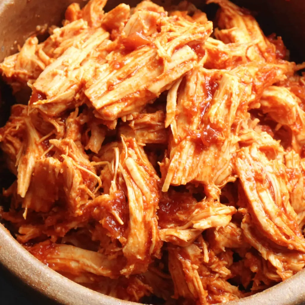 Easy Crockpot Pulled Chicken BBQ Close-up of juicy BBQ Pulled Chicken Crockpot shredded and ready to be served.