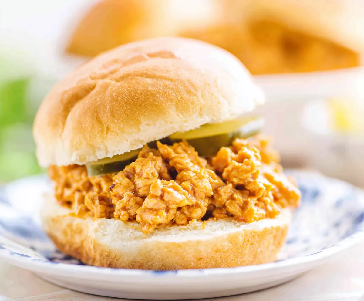 A close-up shot reveals the saucy and flavorful Cajun Chicken Sloppy Joes, piled high on toasted buns.