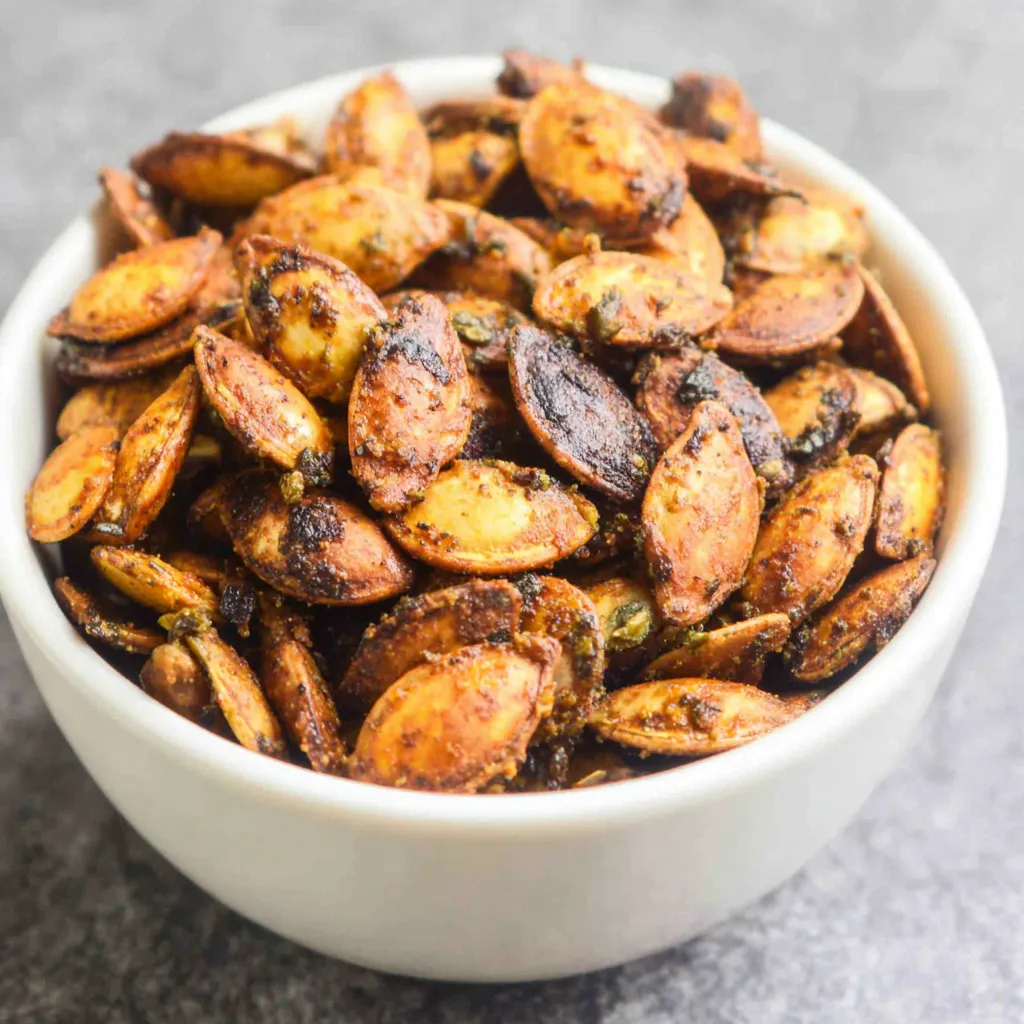 Spicy Cajun Baked Pumpkin Seeds Close-up shows perfectly seasoned Baked Cajun Pumpkin Seeds, ready to eat.