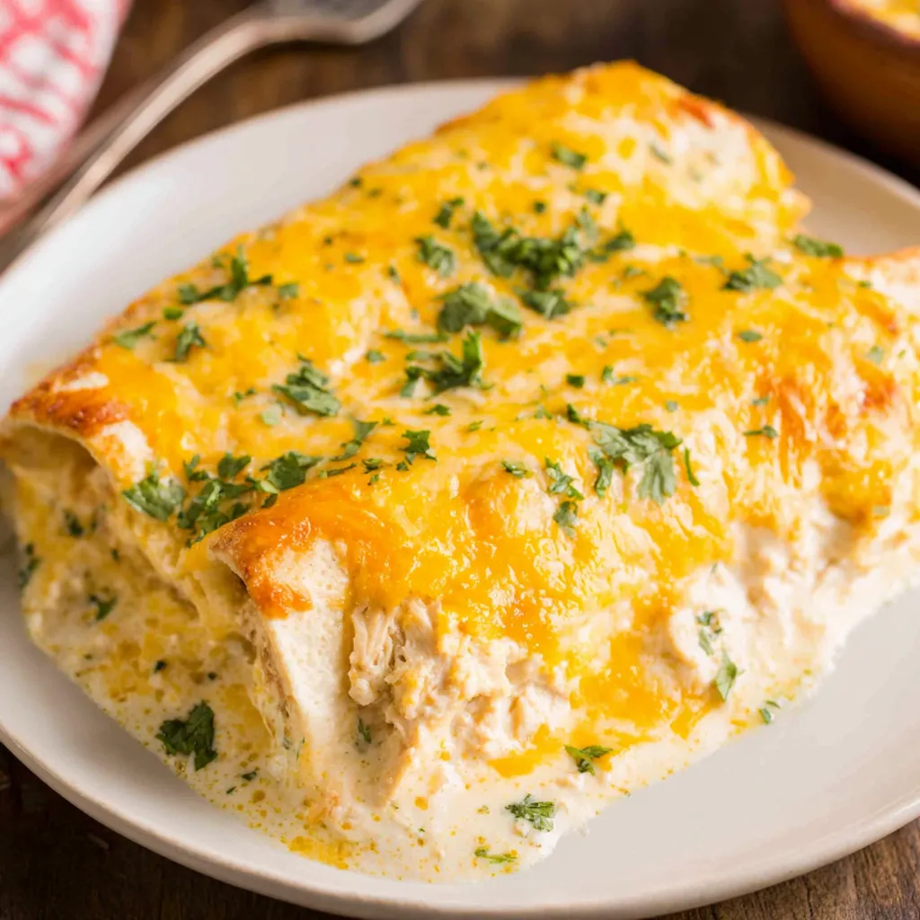Close-up shot of cheesy White Chicken Enchiladas ready to be served in an article about easy Mexican recipes.