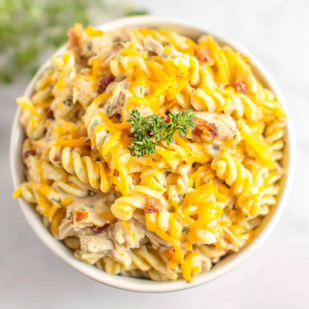 Creamy Crockpot Chicken Bacon Ranch Pasta served in a white bowl, showcasing its cheesy texture and delicious ingredients.