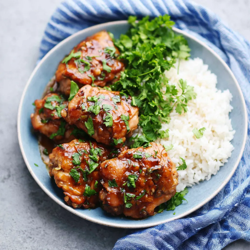Close-up of juicy Slow Cooker Honey Garlic Chicken served with rice and broccoli.