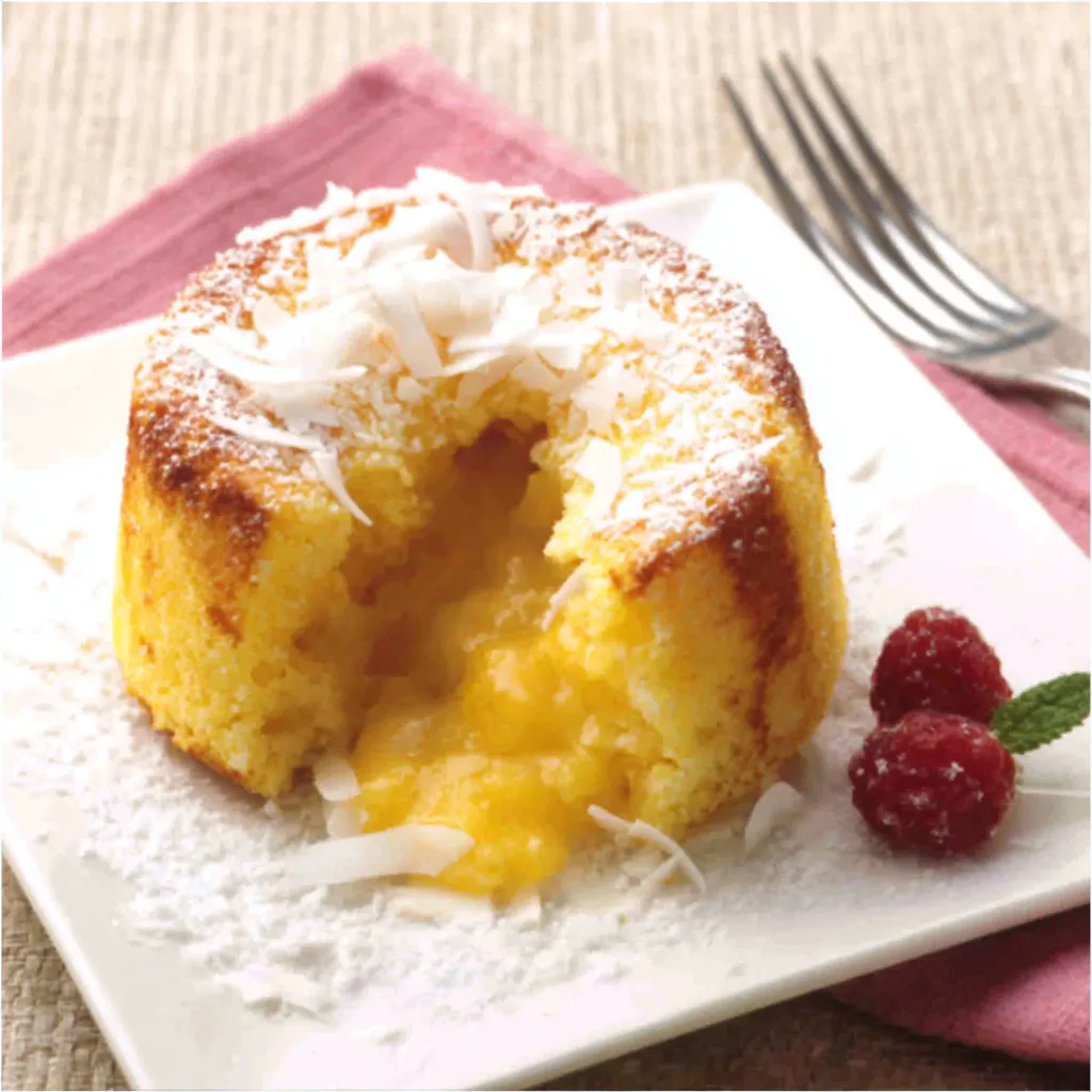 A close-up shot showcases the creamy, gooey center of a freshly baked White Chocolate Molten Coconut Cake.