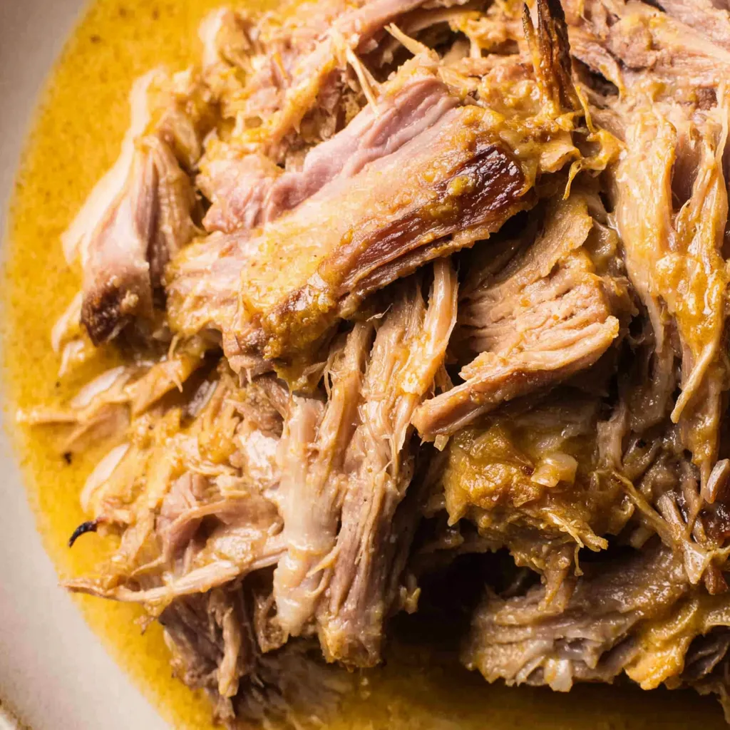 Close-up shot showcasing the tender and juicy Apple Cider Braised Pork Shoulder after slow cooking.