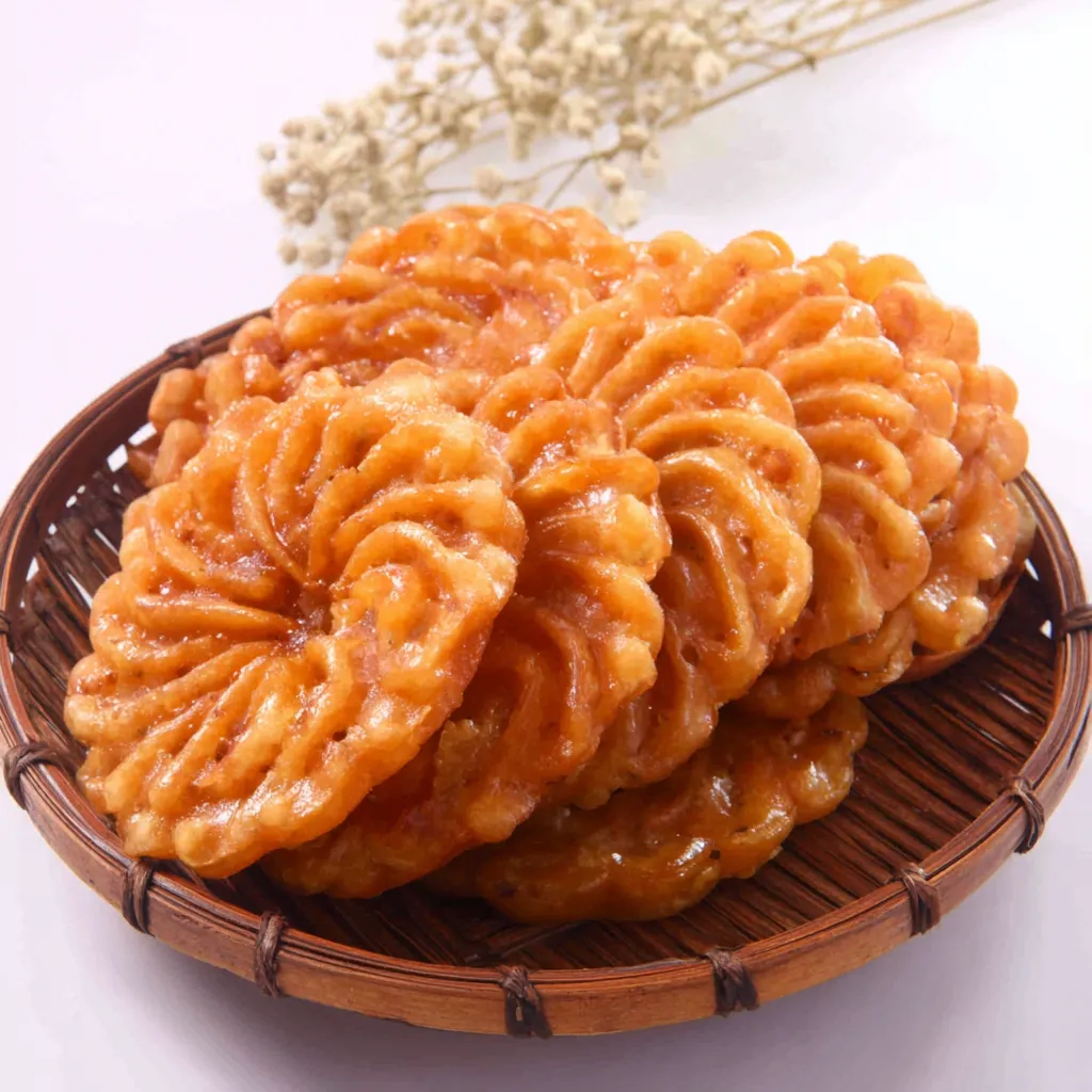 Close-up shot of glistening Yakgwa Korean Honey Cookies, showcasing their intricate design and golden-brown color.