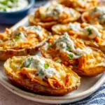 Close-up of crispy Buffalo Chicken Potato Skins, showcasing the melted cheese, shredded chicken, and buffalo sauce drizzle.